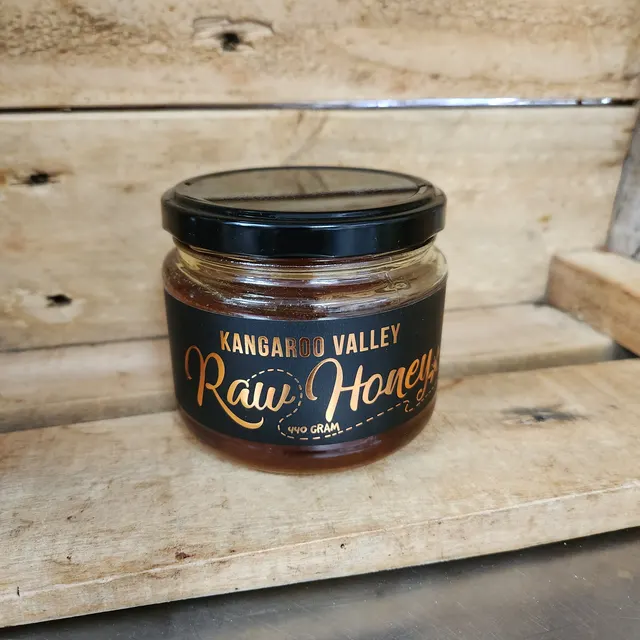 A jar of Kangaroo Valley Raw Honey with a black and copper label.