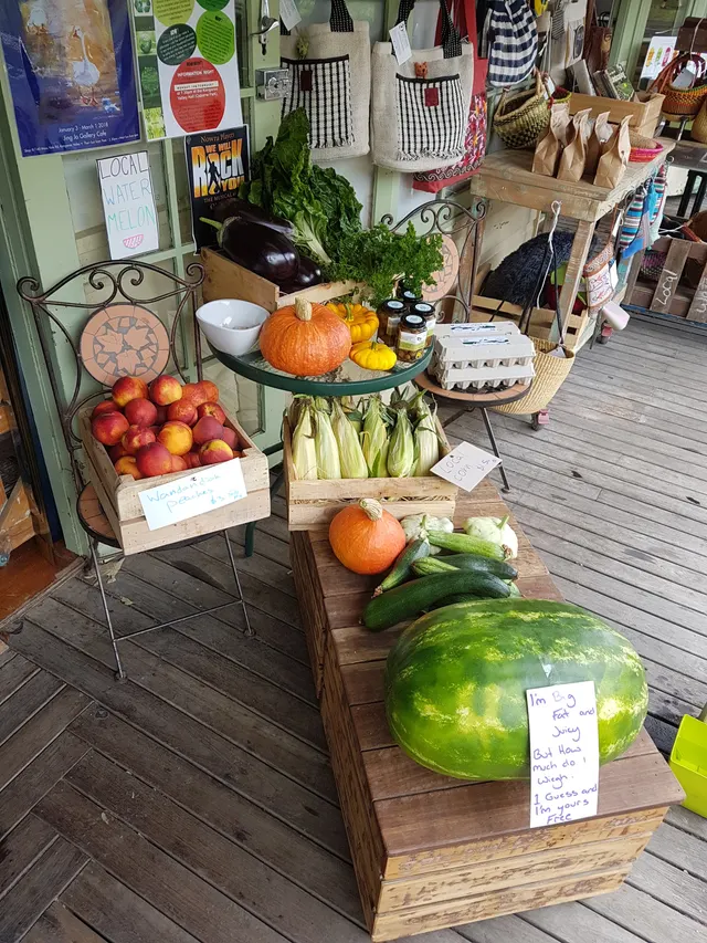 The produce stand inside the door: pumpkins, corn, apples and zucchini.
